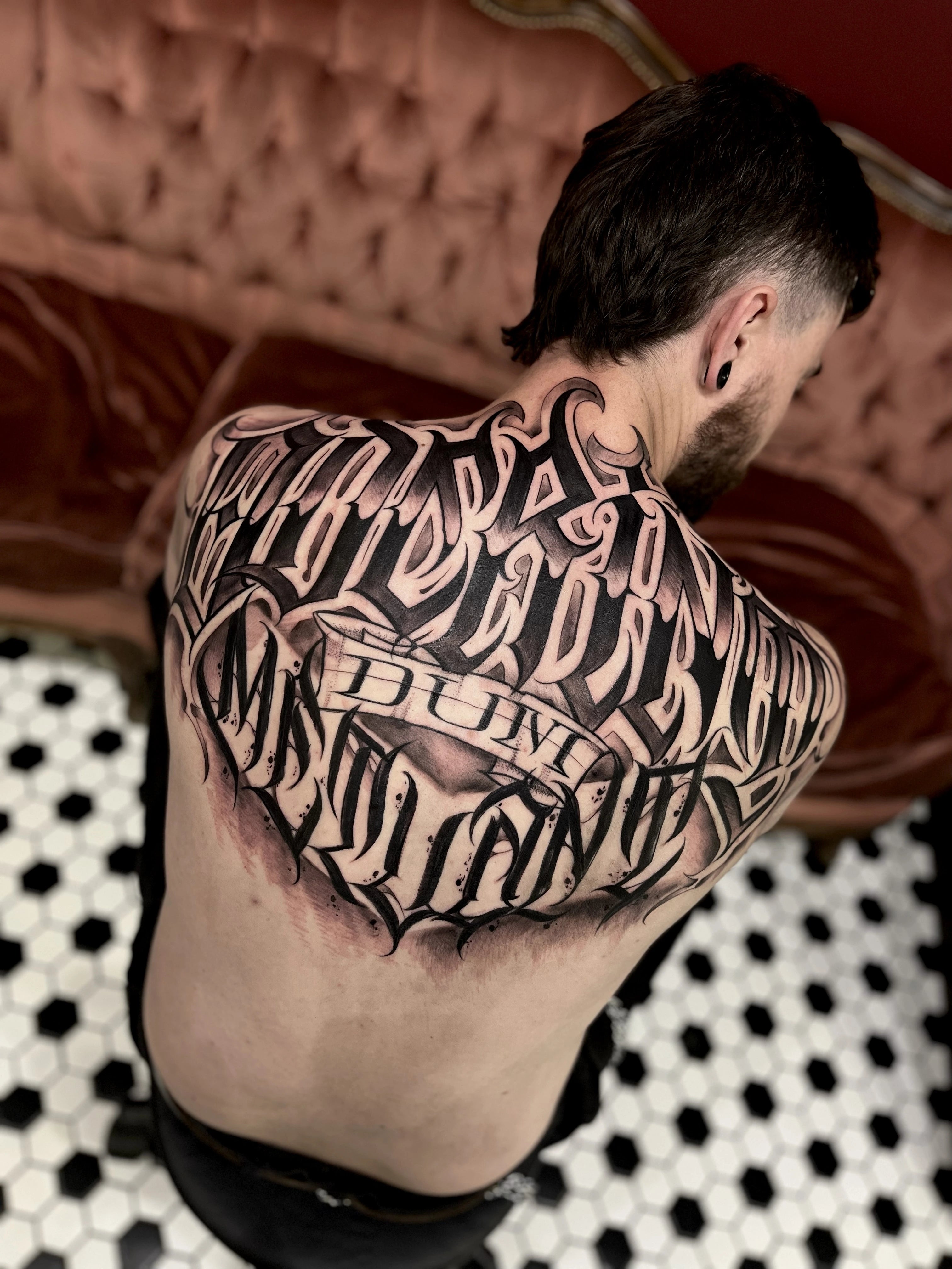 full back script tattoo for men done in London at Sacred Gold Tattoo by Angel 